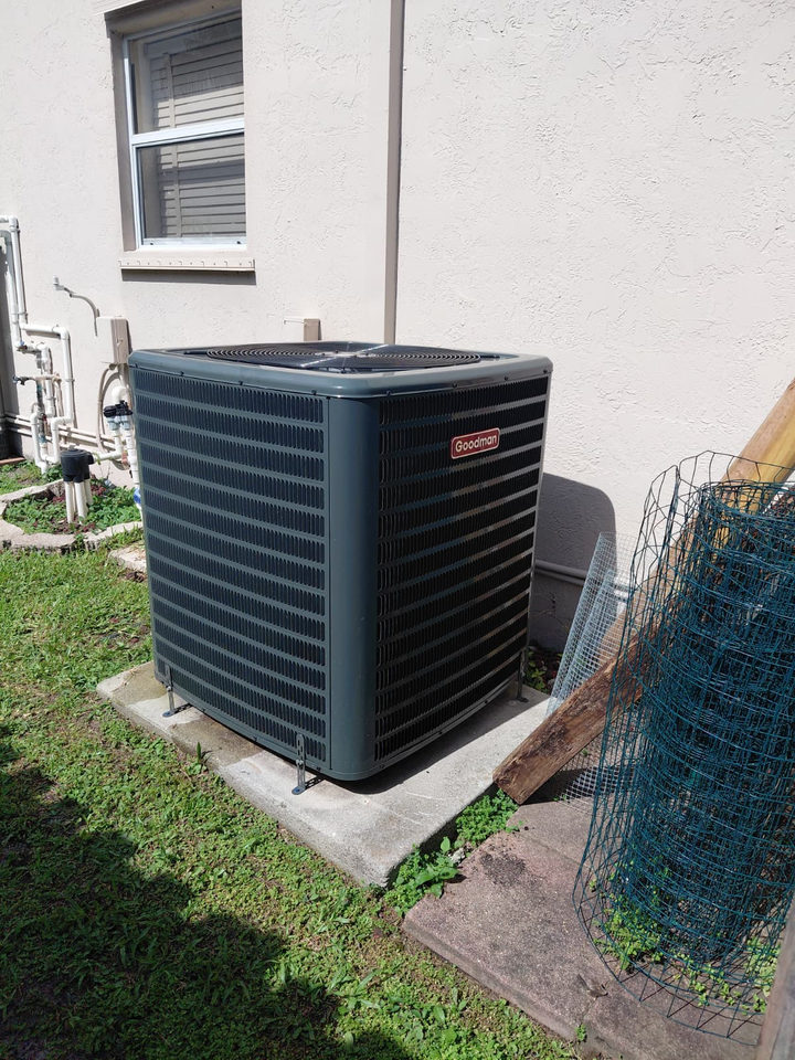 Residential outdoor A/C compressor beside a South Florida home